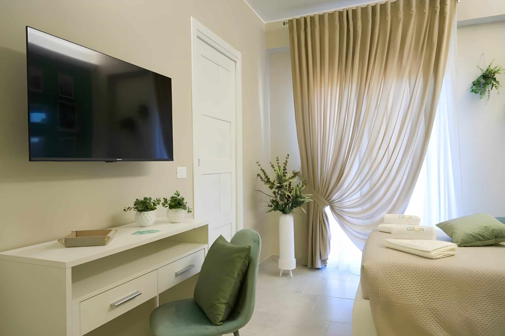 Camera Verde Deluxe del B&B Colors Lesina con letto matrimoniale, scrivania e TV a schermo piatto